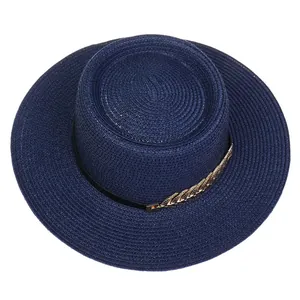 Detailed close-up of dark blue boater hat with delicate golden leaf chain and woven texture