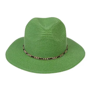Detail view of woven green Panama hat with gold chain and black ribbon trim