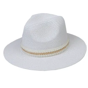 Détail de la paille tressée blanche avec ruban de perles et chaîne dorée élégante