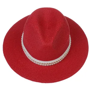 Détail du chapeau Panama rouge avec perles blanches et décoration de chaîne métallique