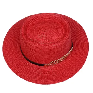 Close-up of red straw boater hat featuring fine weave and gold chain detail