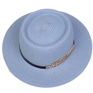 Detail of light blue straw hat featuring black ribbon and gold leaf metal buckle