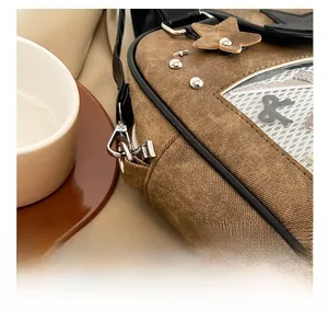 Close-up of brown canvas bag with star leather patch, silver studs and metal buckle
