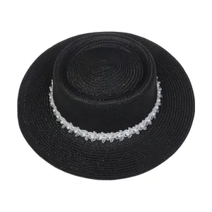 Detailaufnahme von schwarzem Strohhut mit eleganter Perlen- und Blumenverzierung
