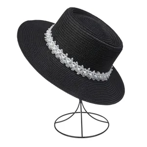 Detail eines schwarzen Kreissägers mit elegantem weißem Perlenblumenschmuck auf Hutständer