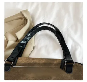 Detail show of corduroy tote bag with black leather handle and silver metal D-ring hardware