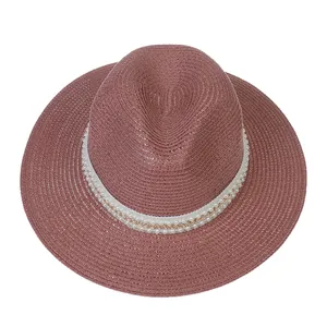 Détail d'un chapeau Panama mauve montrant la texture paille, perles et chaîne dorée