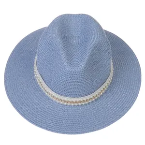 Détail du chapeau Panama bleu clair en paille avec chaîne élégante en perles et or