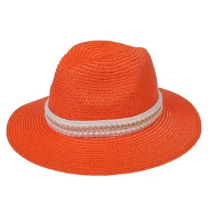 Détail d'un chapeau Panama orange orné de perles blanches et d'une chaîne dorée