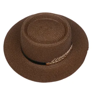 Detailed macro view of dark coffee straw boater hat with gold leaf metal ornaments
