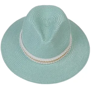 Détail du chapeau Panama vert menthe avec bordure en perles et chaîne dorée élégante