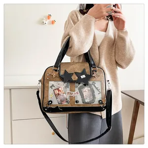 Close-up of brown faux leather ita bag with clear PVC window and star patches
