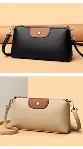 Detalle de bolsos para móvil en cuero granulado para mujer, tonos negro y beige crema.