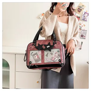 Detail of red tote ita bag with transparent window and star charms worn by model