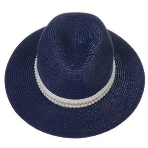 Détail d'un chapeau Panama bleu marine avec perles et ornements de chaîne dorée