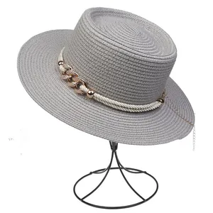 Close-up of grey boater straw hat featuring white braided rope and gold metal chain detail
