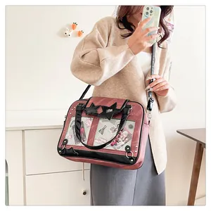 Detailed view of red-brown ita bag with transparent window and cartoon accessory