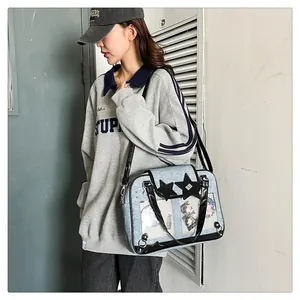 Detail of light blue denim itabag with black star patches and clear badge display layer
