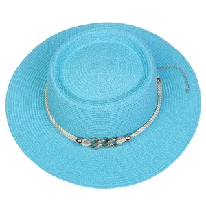 Detail of light blue straw boater hat featuring pearl decorations and metal chain accents
