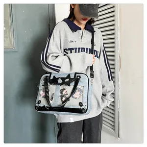 Detail of blue ita-bag with transparent windows showing anime pins and star buckle