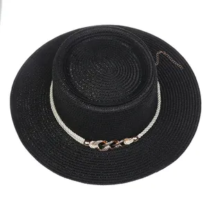 Detail of black woven straw boater hat featuring pearl rope and golden chain decoration