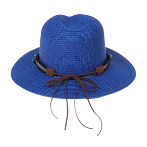 Détail d'un chapeau Panama bleu roi tressé avec ruban marron et boucle métallique argentée