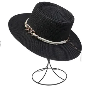 Detail of black straw boater hat with white rope and golden chain on a display stand