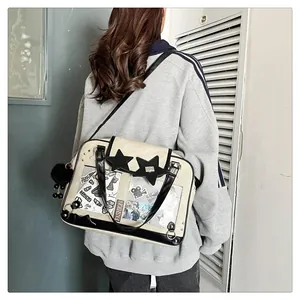 Detail of beige ita bag featuring transparent PVC window and black star leather patch