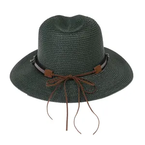 Détails de la texture d'un chapeau Panama en paille vert foncé avec ruban en cuir brun