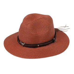 Détail d'un chapeau de paille rouille avec bande en cuir et ornement tête de taureau