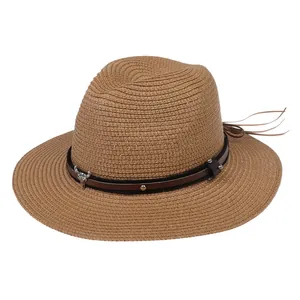 Détail du chapeau de paille marron avec bandeau en cuir et ornement tête de buffle argent