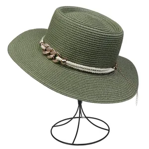 Close-up of olive green straw hat with twisted rope and gold chain link decoration