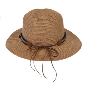 Détail d'un chapeau Panama en paille marron foncé avec ruban en cuir et nœud élégant