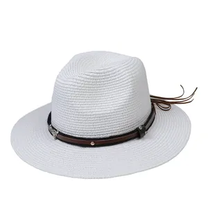 Détail d'un chapeau Panama en paille blanche avec ruban cuir, pendentif taureau et clous