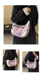 Detail of light purple and white contrast hobo bag with front zipper and branded tag