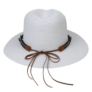 Détail d'un chapeau Panama en paille tressée blanche avec un ruban en cuir marron