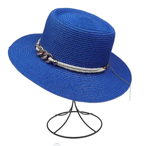 Detailed view of royal blue boater hat with woven rope and gold chain decoration
