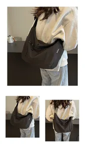 Detail of a large black crossbody bag showing matte texture and adjustable strap