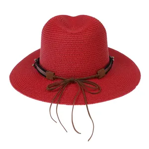 Détail du chapeau Panama rouge en paille avec ruban décoratif marron foncé et nœud