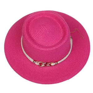 Detail of vibrant rose red straw boater hat with white rope and gold metal buckle