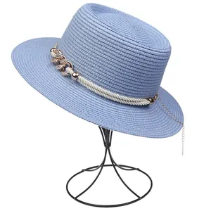 Detailed view of light blue woven straw fedora hat with elegant gold chain and rope trim