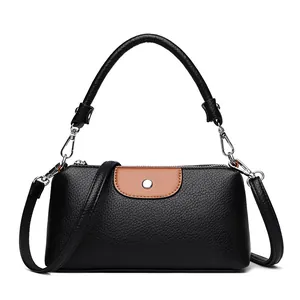 Elegante mini bolso de mano de cuero negro con solapa marrón para una mujer moderna.