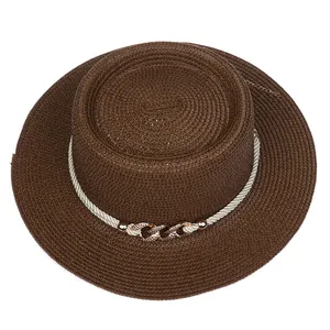 Close-up of brown straw hat featuring white braided rope and golden diamond buckle detail