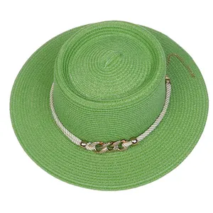 Detail of green straw boater hat with metallic gold chain and pearl flower accents