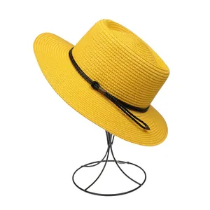 Detail of yellow woven straw hat featuring a flat top and black cord decorative band