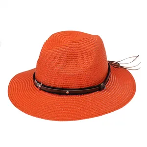 Détail du chapeau de paille orange avec bandeau en cuir brun et ornement tête de taureau