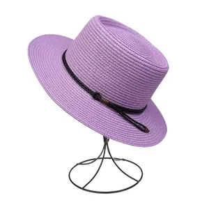 Detailed macro view of lavender woven straw hat featuring black rope and metal accents