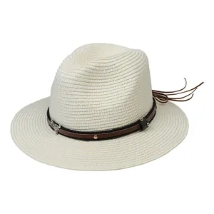 Détail du chapeau Panama avec bande en cuir marron, rivets et emblème de tête de taureau