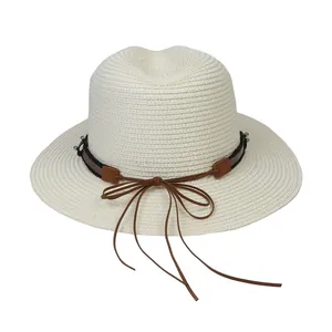 Détail du chapeau Panama ivoire avec ruban foncé et nœud en cuir marron élégant