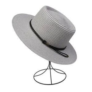 Detail of light gray straw sun hat with woven black band and vintage metal buckle